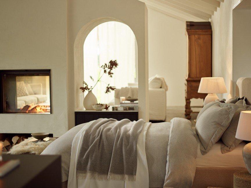 a bedroom with a bed, fireplace, and lamps in the room