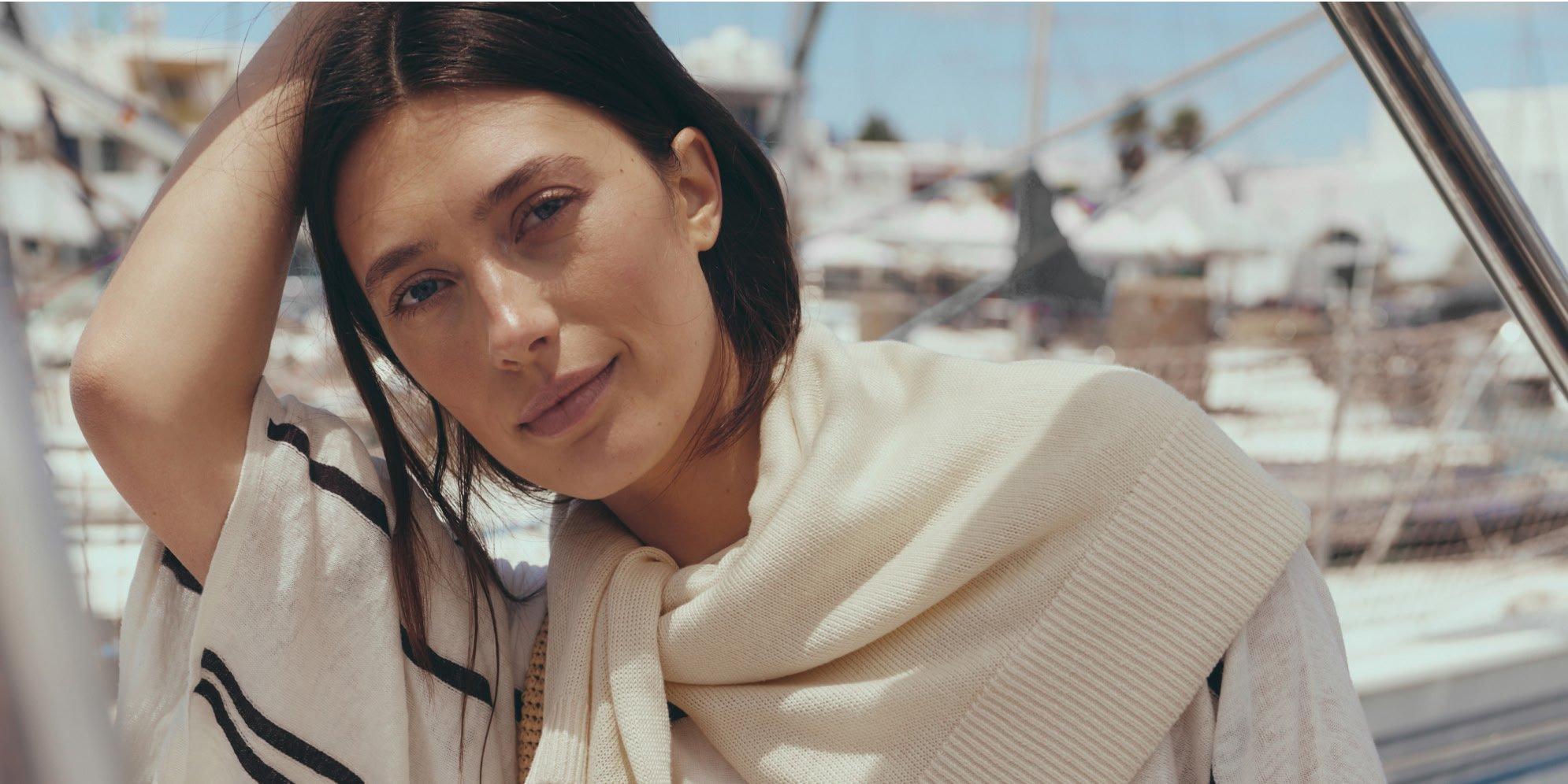 a woman standing in front of a body of water
