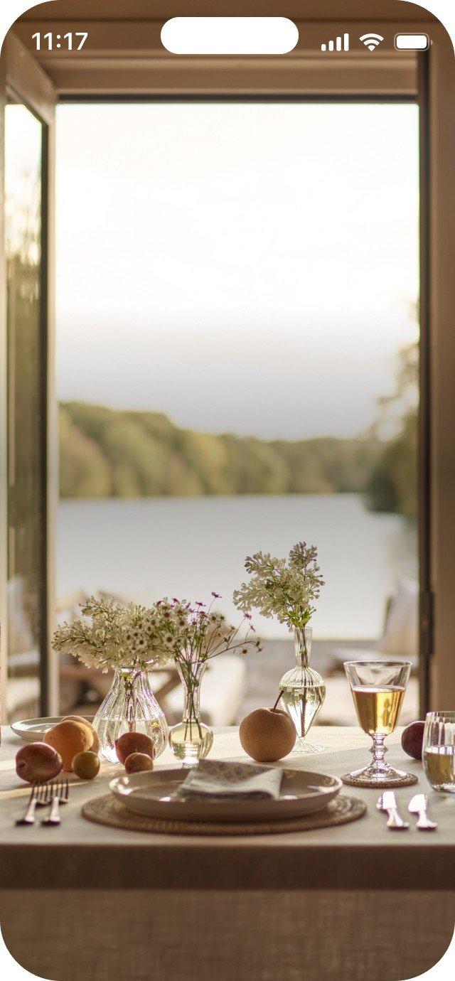 a table with a vase of flowers and a plate of food