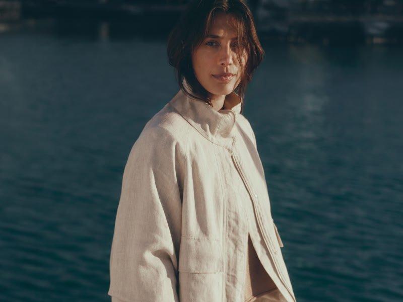 a woman standing in front of a body of water