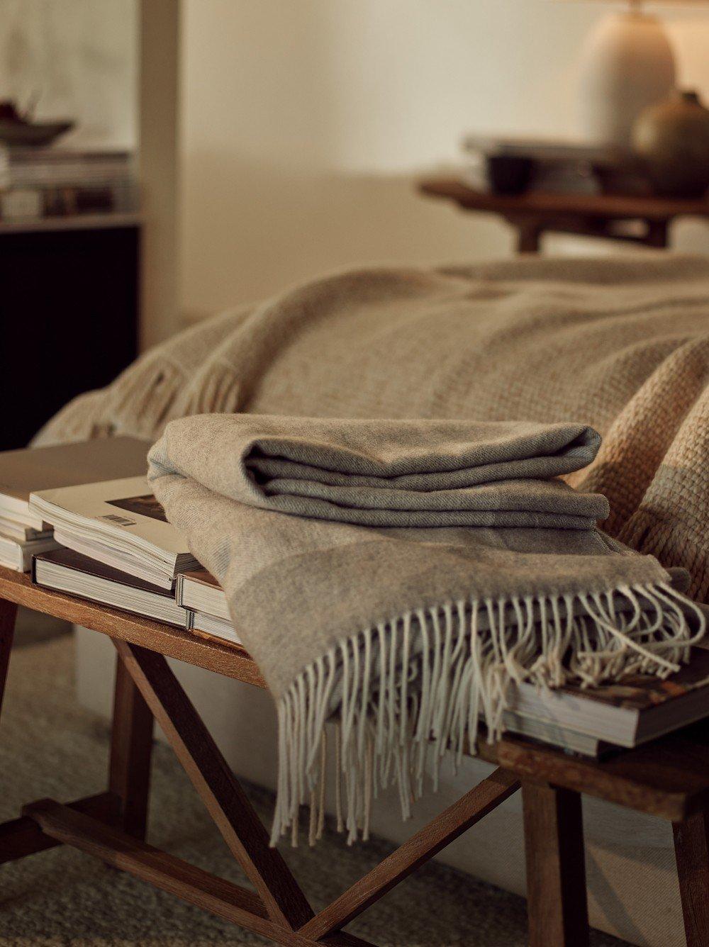 a bed with a white comforter and a basket of items