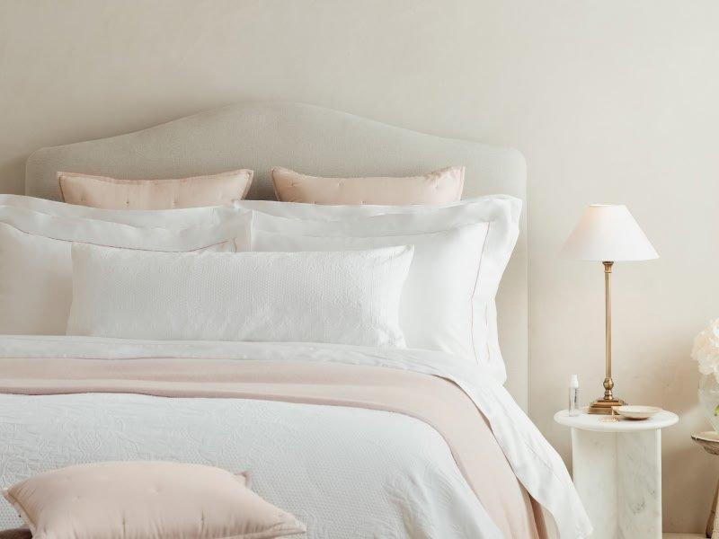 a bedroom with a white bed and a chair in it