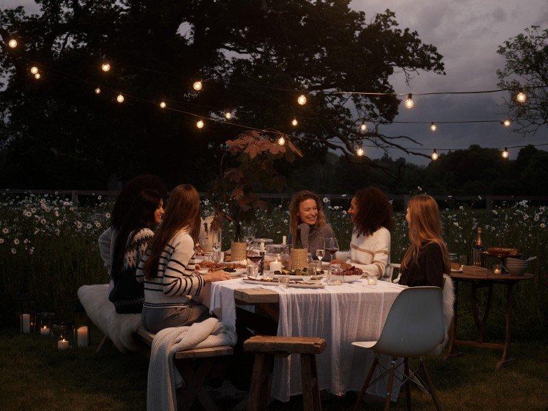 a group of people sitting around a table eating dinner