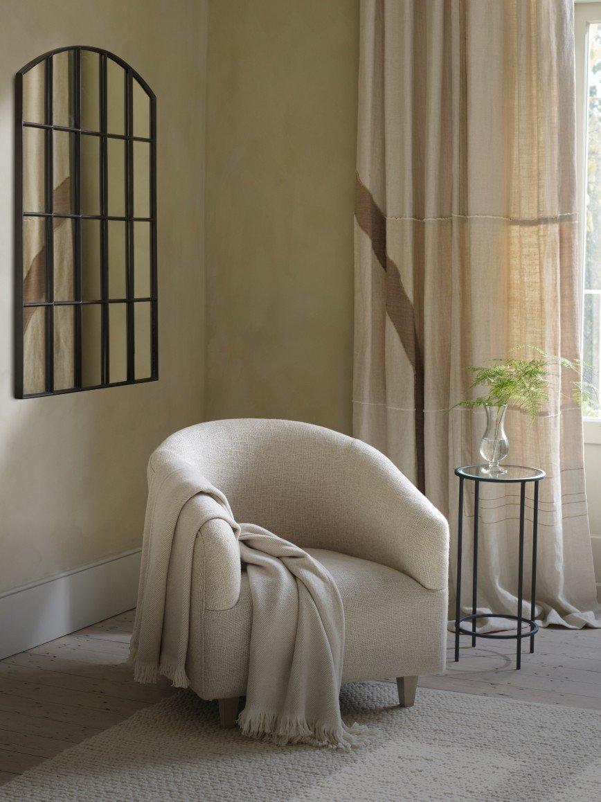 a white chair sitting in a room with a window and a table