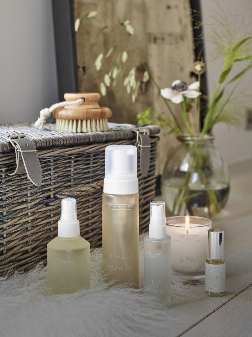 a bowl of soaps and lotions on a towel on a table