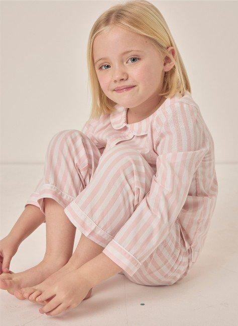 a little girl sitting on the floor with her feet crossed