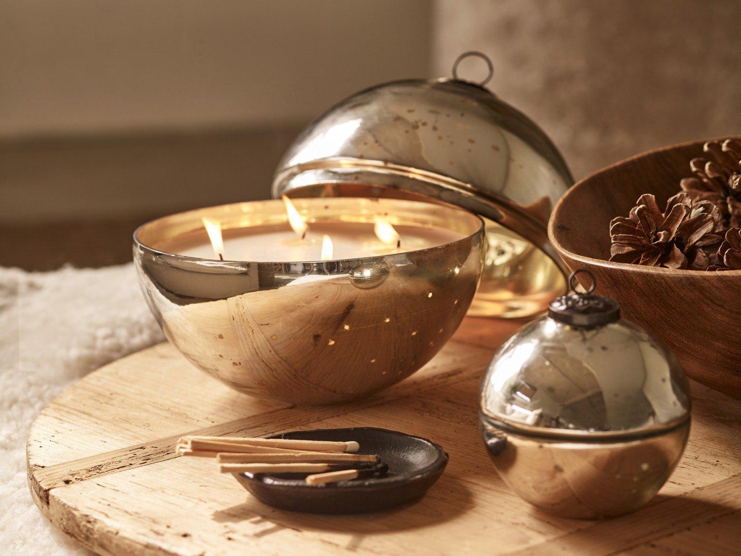 a wooden table with a candle, a bowl and a candle holder