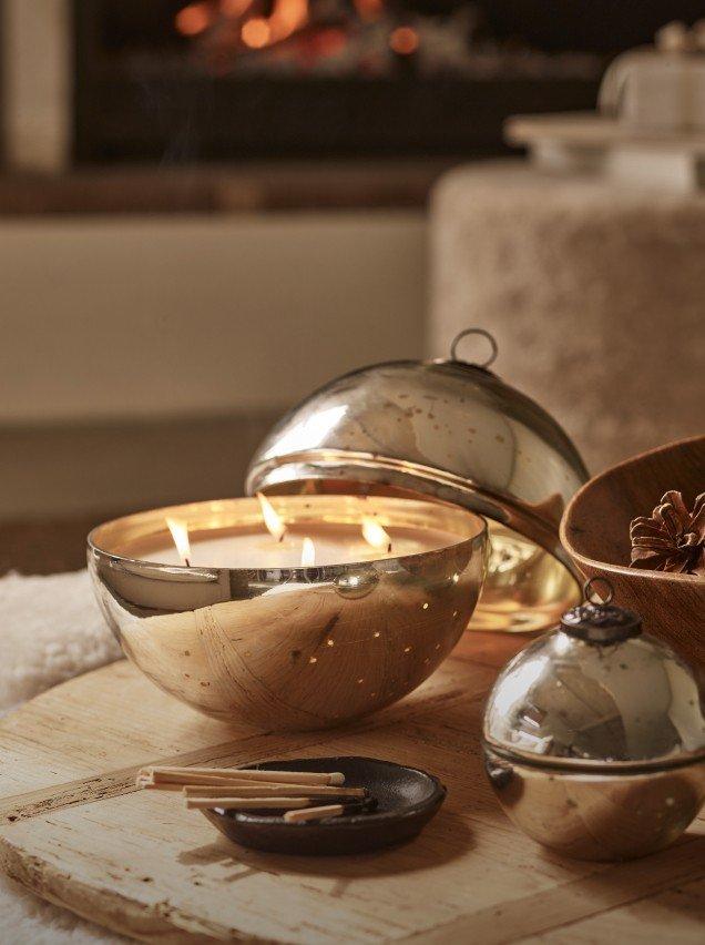 a wooden table with a bowl of candles and a bowl of nuts