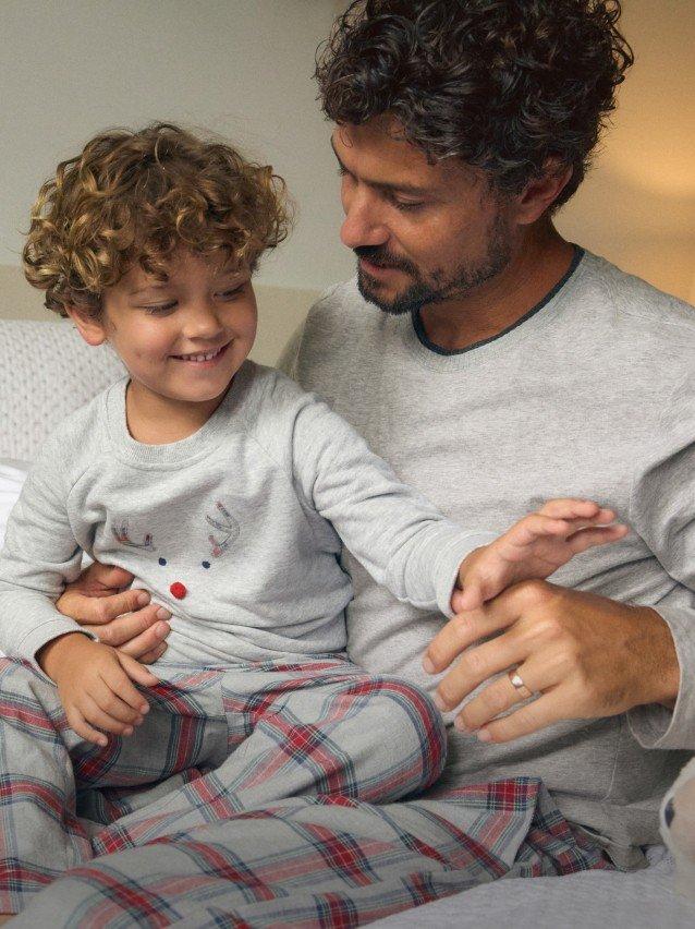 a man and a little boy sitting on a bed together