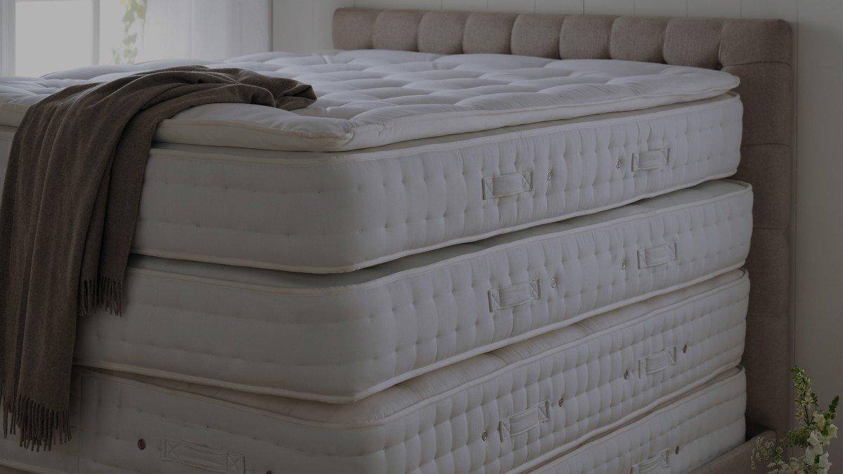 a stack of four mattresses in a room with a window