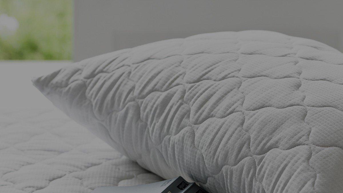 a pillow with a book on it sitting on a bed