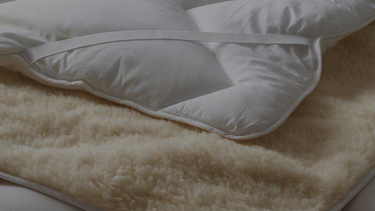 a close up of a bed with a blanket and pillows