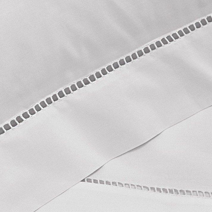 a close up of a white sheet with blue piping