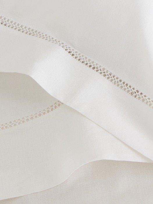 a close up of a white sheet with a lace trim