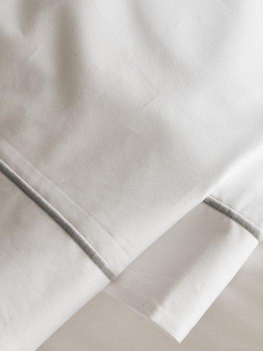 a close up of a white sheet with a silver stripe