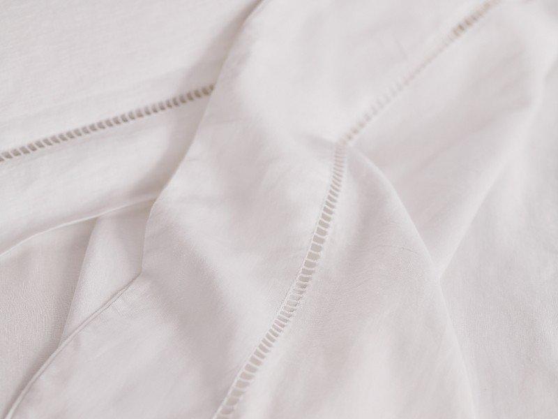 a close up of a white sheet with a zipper on it