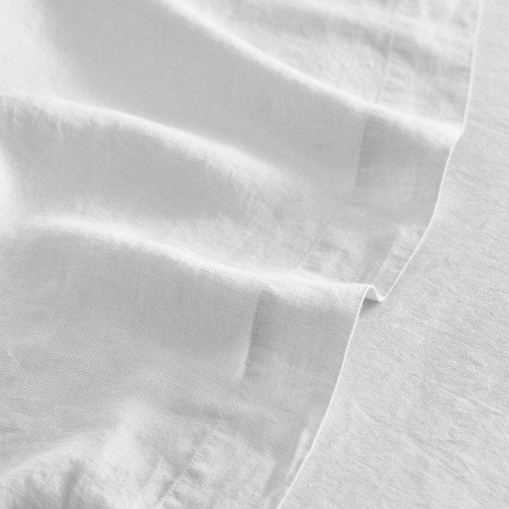 a close up of a white sheet with a white pillow