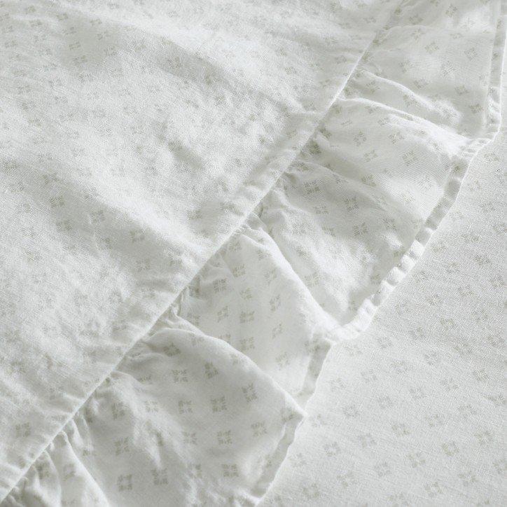 a close up of a white sheet with ruffles on it