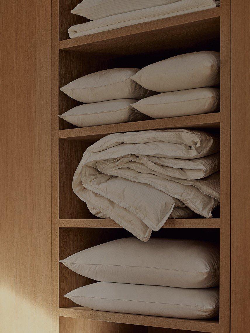 a wooden shelves with pillows and blankets on them in a room