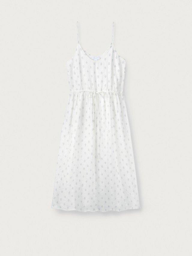 the white dress with polka dots is hanging on a hanger