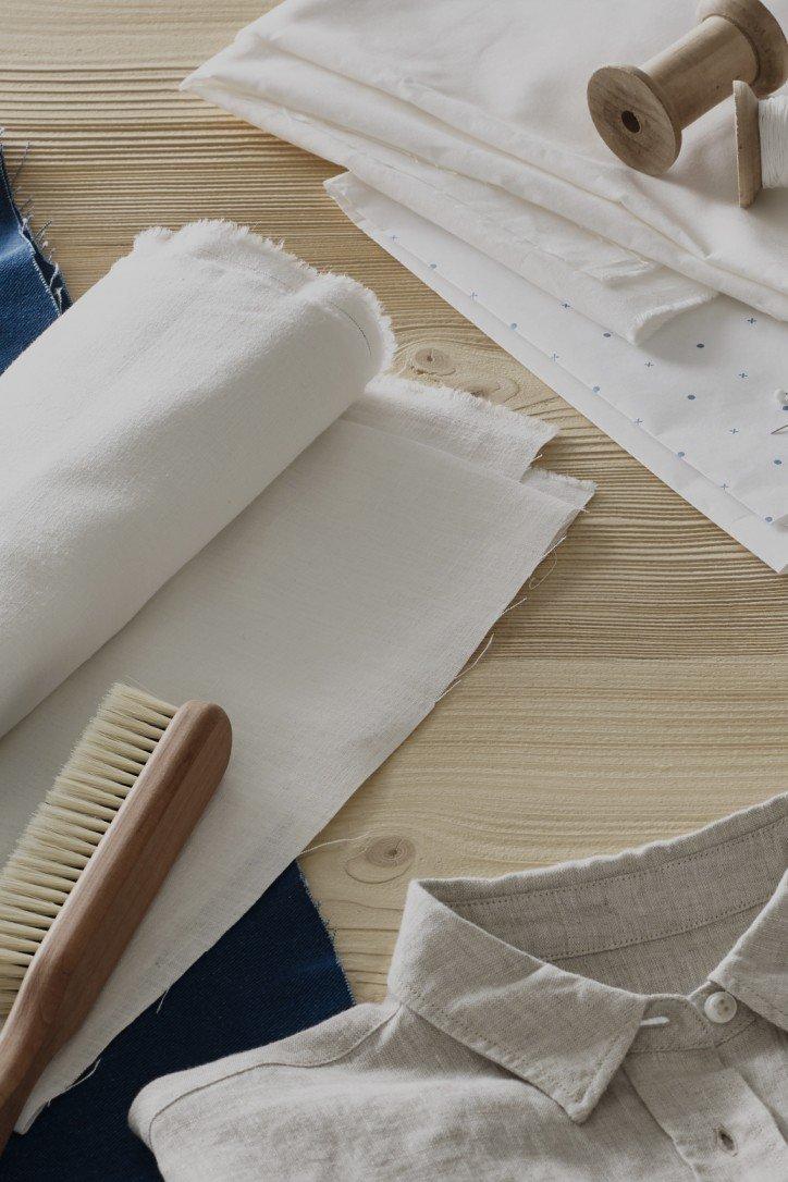 a wooden table with a shirt, a comb, and some fabric