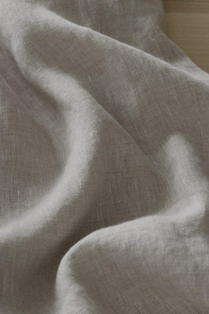 a close up of a gray fabric laying on a bed