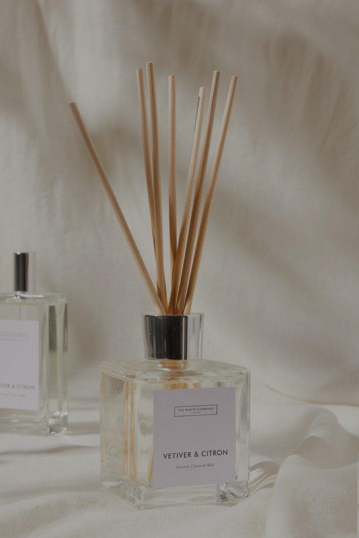 two reed diffusers are sitting on a white cloth on a table