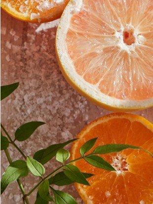 a close up of a grapefruit and a leaf on a table