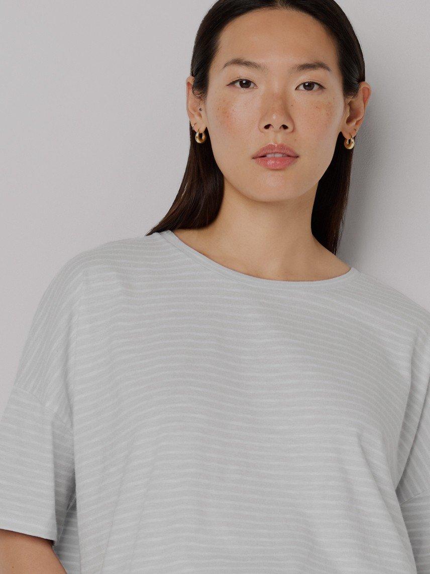 a woman with long hair and a white shirt posing for a picture