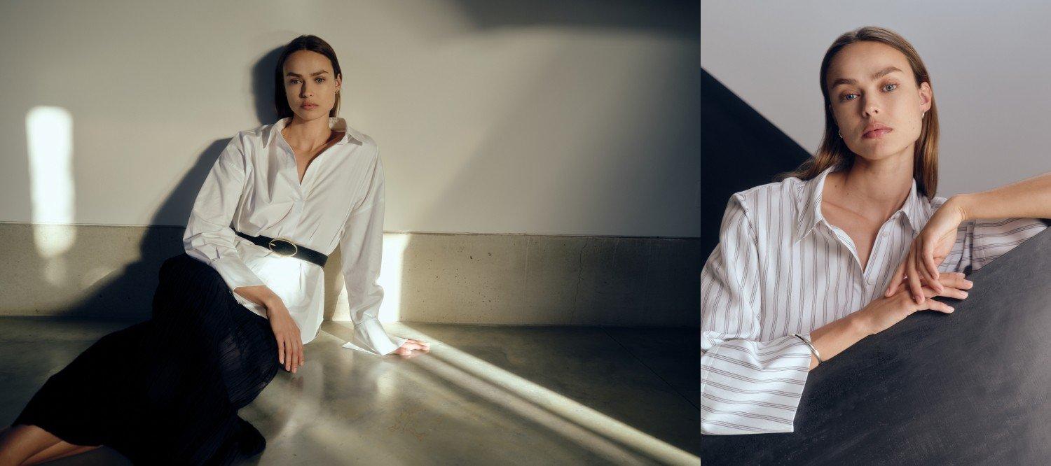 a woman sitting on a floor in a white shirt and black pants