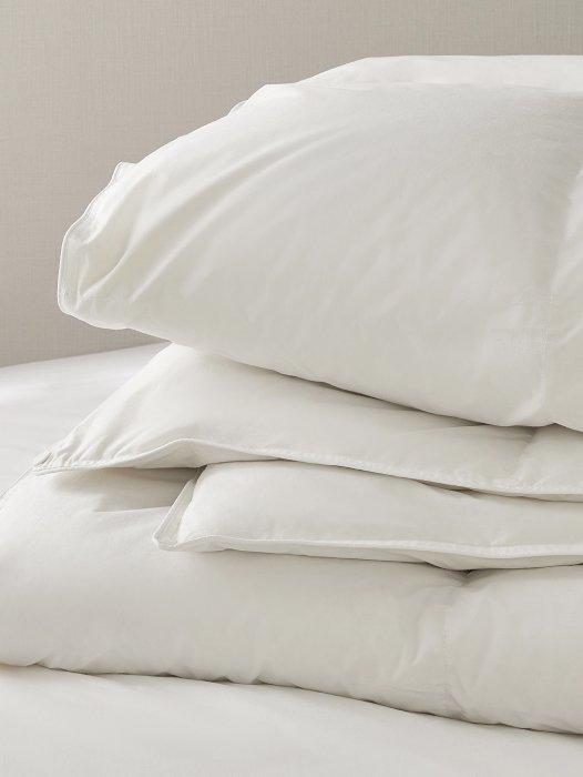 a stack of white pillows on top of a bed