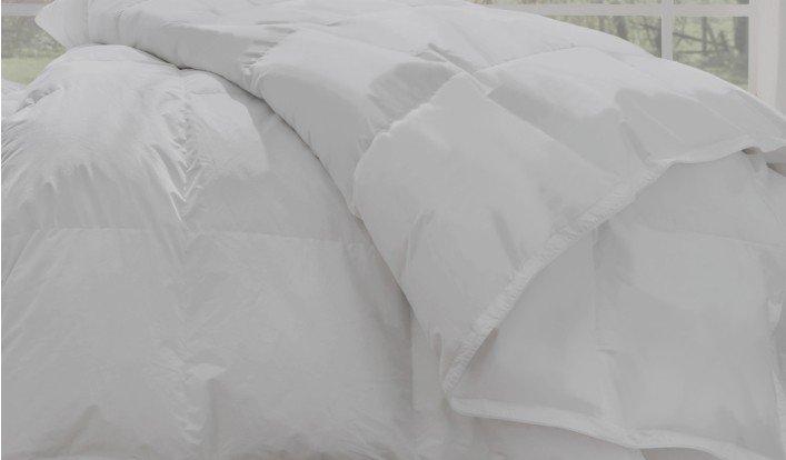 a white comforter is folded up on a bed