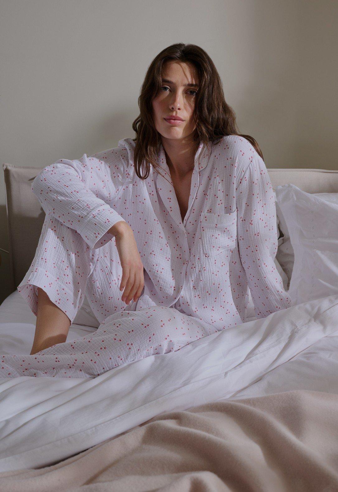 a woman sleeping in a bed with a white sheet