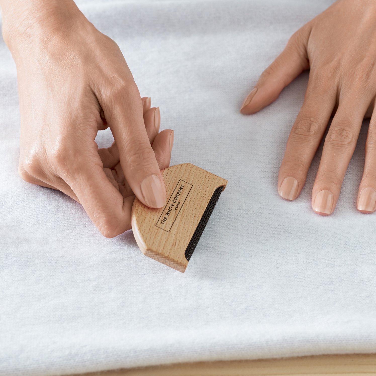 a person using a wooden block to smooth out a piece of fabric