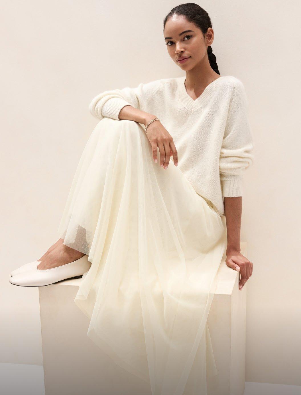 a woman in a white dress sitting on a box