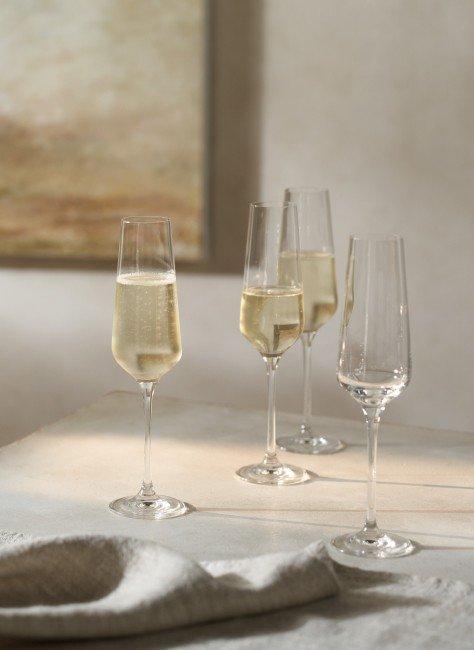 a group of wine glasses on a table with a painting