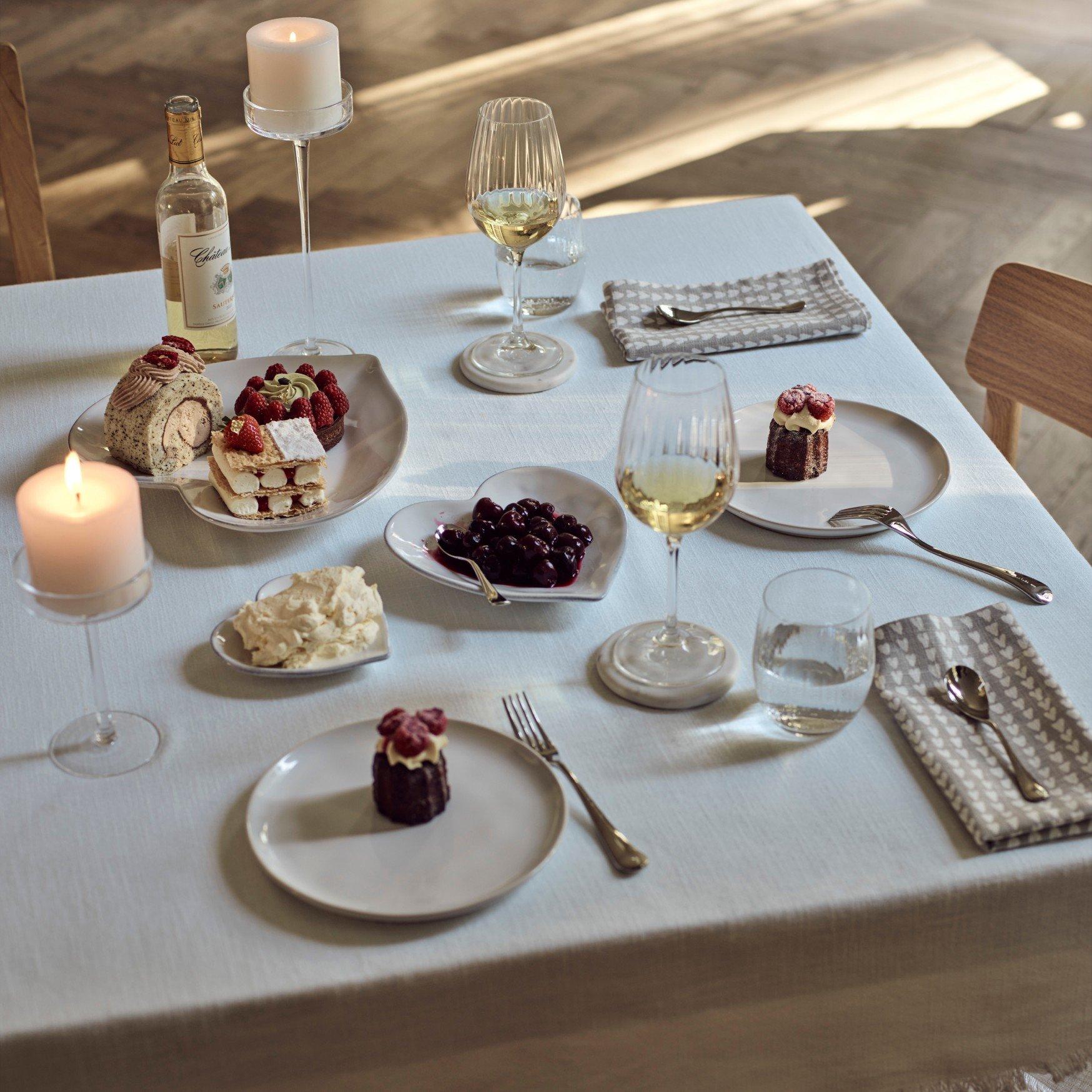 a table with a plate of food and wine glasses on it