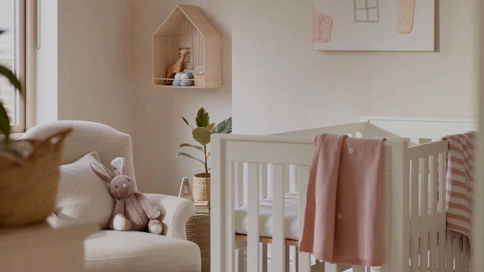 a baby's room with a crib, chair, and rug