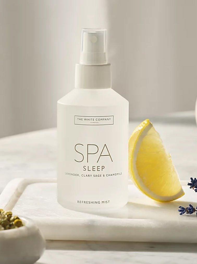a bottle of spa sleep on a tray with a lemon slice