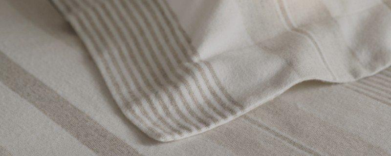 a bed with a white sheet and a white pillow on it