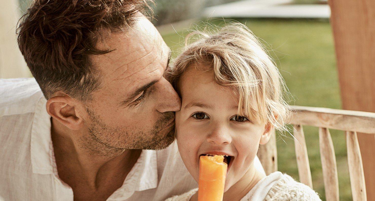 a man and a little girl eating a carrot together