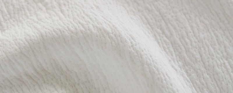 a close up of a white sheet of fabric with a bird on it