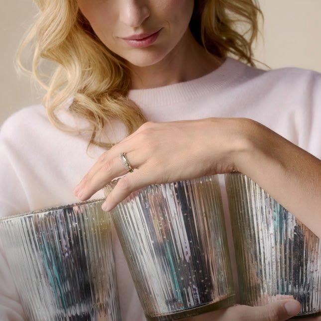 a woman holding a bunch of silver cups together