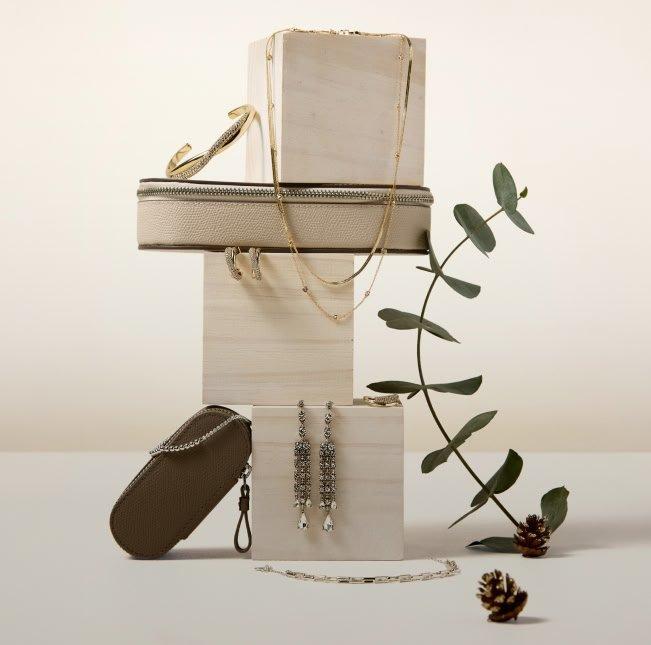 a pile of jewelry and accessories on a table with a plant