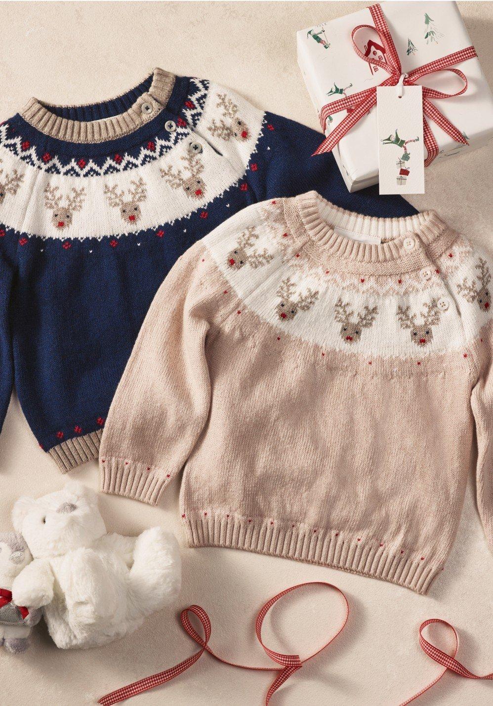 two sweaters and a teddy bear are sitting next to a gift