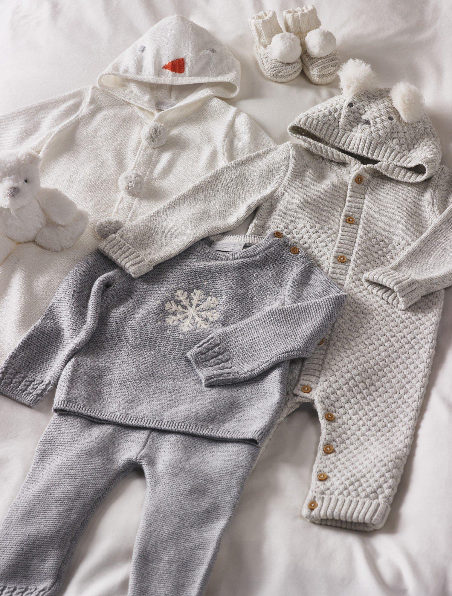 a baby outfit is laid out on a bed with a stuffed animal