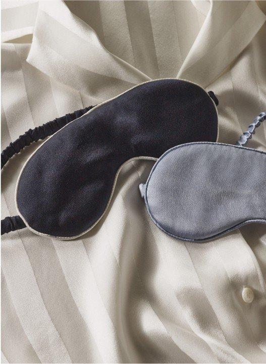 a pair of black and grey sleeping masks on a white sheet