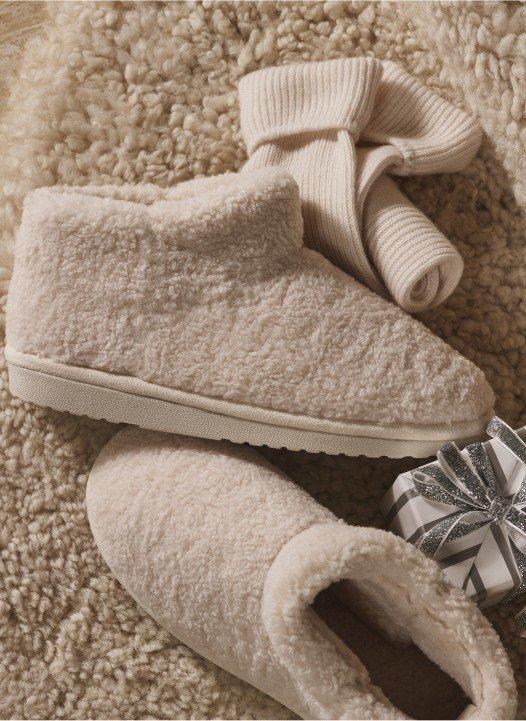 a pair of slippers and a gift wrapped in a bow on a carpet