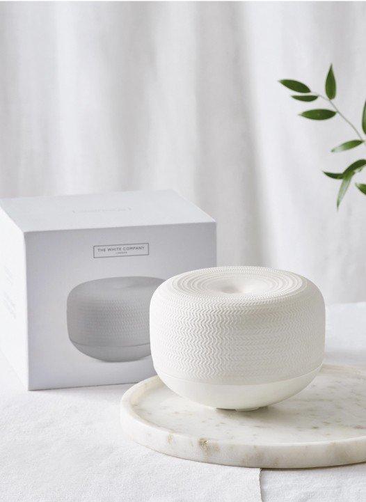 a white object sitting on a marble table next to a plant