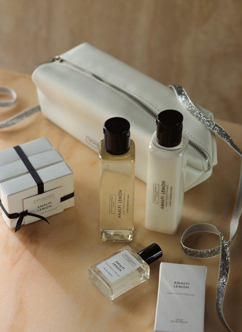 a white bag with a white purse and a white bottle of perfume